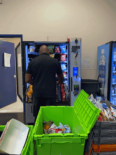 Jonah, an employee of Canteen Vending, restocking the lobby vending machine in Westport